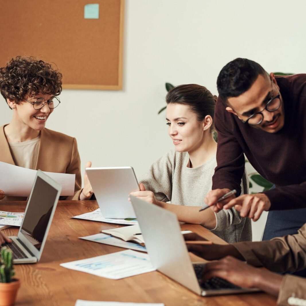A diverse group of professionals engaged in a collaborative office meeting, sharing ideas and discussing projects.