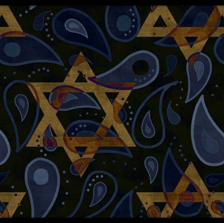 Three children engaged in learning activities inside a classroom, with one raising her hand.